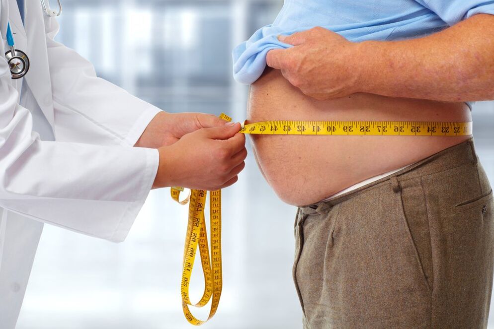 лекарят измерва талията на пациента на диета